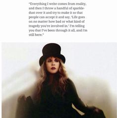 a woman sitting on the ground wearing a black hat and dress with words written below her