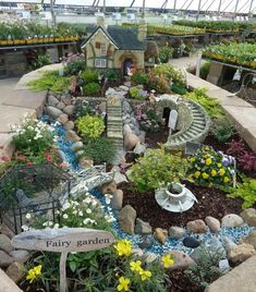 a garden filled with lots of plants and flowers next to a sign that says fairy garden