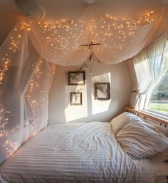 an image of a bedroom with lights on the ceiling and curtains over the bed,