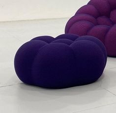 two purple chairs sitting on top of a white floor