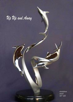 a metal sculpture with two dolphins on it