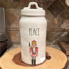 a ceramic jar that says peace with a nutcracker holding a flag on it