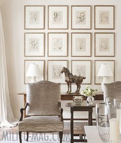 a living room filled with furniture and framed pictures on the wall above it's coffee table