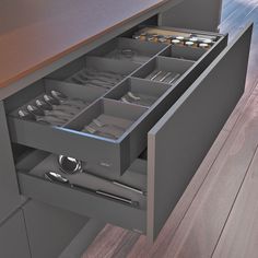 an open drawer in a kitchen with utensils and silverware on the drawers