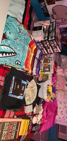 there are many items on the bed spread out in this room, including t - shirts and other things