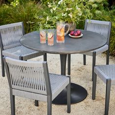 an outdoor table with four chairs around it