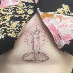 a woman's back with a tattoo on her stomach and an image of a mermaid