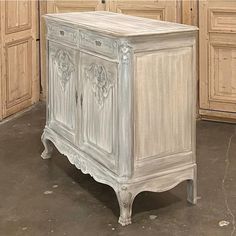 a white cabinet sitting in the middle of a room next to wooden cabinets and cupboards