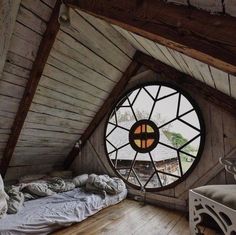 an instagram photo of a bedroom with a large round window in the ceiling and wood flooring