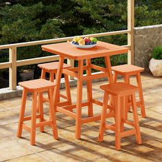 an orange table and stools on a patio