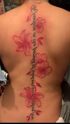 a woman's back with flowers on it and the words written in cursive writing