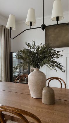 a large vase sitting on top of a wooden table next to a lamp and chair