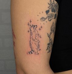 a woman's arm with a tattoo on it that has a bear and stars