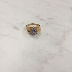 14kt Yellow Gold Lady's Diamond and Tanzanite Ring consisting of a 7mm x 5mm genuine Oval Tanzanite gemstone approx. 1.00ct total weight and 12 full cut round brilliant diamonds .25ct total weight SI clarity, H color all prong set surrounding the Tanzanite in a halo effect. The sparkle and glitter that comes from this ring will pack a punch for the wearer. The tapered shank will be comfortable and is a size 7. This Item would Retail for $875.00 Classic Tanzanite Gold Ring, Classic Gold Tanzanite Ring, Gold Tanzanite Gemstone Rings, Gold Tanzanite Birthstone Promise Ring, Gold Tanzanite Rings With Accent Stones, Gold Tanzanite Birthstone Ring For Formal Events, Gold Tanzanite Birthstone Ring For Formal Occasions, Classic Tanzanite Birthstone Promise Ring, Gold Tanzanite Birthstone Ring