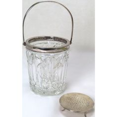 a glass jar with a strainer next to it