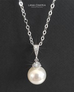 Wedding Swarovski 10mm White Pearl Drop 925 Sterling Silver Chain CZ Bridal Necklace. CHAIN is 18 inches (45.7 cm) long. PENDANT is about 1 inch (2.4 cm) long including bail. MATCHING EARRINGS: https://www.etsy.com/listing/95683858/white-pearl-drop-bridal-earrings?ref=shop_home_active_2 This necklace is made with 925 Sterling Silver chain, Swarovski 10mm White round crystal pearl, Rhodium Sterling Silver pearl component with clear Cubic Zirconia stones, and silver (Original Rhodium) plated bail Classic Pearl Chain Jewelry For Weddings, Classic Silver Bridal Necklace With Pearl Chain, Classic White Gold Necklace For Wedding, White Pearl Pendant Jewelry For Wedding, White Gold Round Bridal Necklace For Wedding, Pearl Chain Pendant Jewelry For Wedding, Wedding Pendant Jewelry With Pearl Chain, Classic Wedding Necklace With Round Pendant, Pearl White Round Bridal Necklace