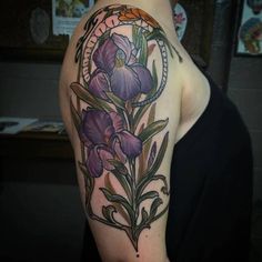 a woman with a tattoo on her arm has purple flowers in a circle around it