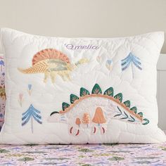 a white pillow with colorful embroidered animals on it