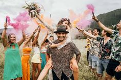 a group of people standing in a field with colored powder on their faces and arms