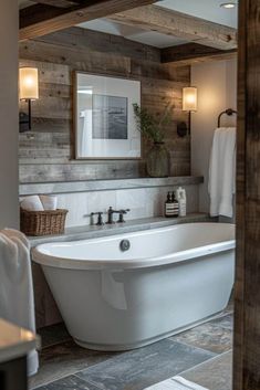 a white bath tub sitting inside of a bathroom next to a wooden framed mirror on the wall