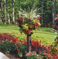 two tall planters filled with colorful flowers in a garden