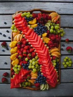 a wooden platter filled with lots of different types of fruit