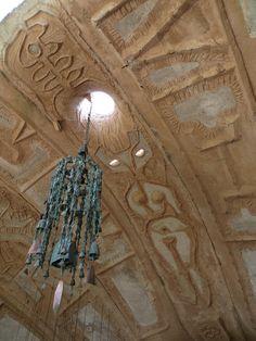 a chandelier hanging from the ceiling in a room with intricate carvings on it