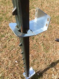 a close up of a metal pole in the grass