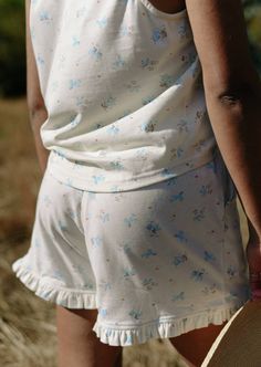 When only the most adorable will do: the Cowboy Dreams Shorts. Tiny blue cowboys dance across this soft cream cotton knit, trimmed with a ruffle hem and finished with a soft elastic waistband. Though inspired by vintage pyjamas, we're sure this style would love to be worn out of the house with the matching cami, or Cactus Clover Tee. Features Roomy pockets Fully elastic waistband Ruffle trim Decorative bow 100% vintage cotton, deadstock sourced Machine wash cold, hang to dry. Size chart - Sized for a relaxed lounge fit. If you are in between sizes, you can size down for a more fitted look. A note from the designer: Storytime. We were originally only going to include the camisole in this collection. But in the eleventh hour (aka - right before our photoshoot) we just couldn't resist whippin Vintage Pyjamas, Skirt And Cowboy Boots, Cowboy Print, Vintage Pajamas, Top With Bow, Split Second, Lounge Top, Denim Cutoffs, Horse Print