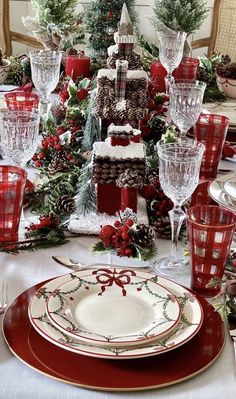 a christmas table setting with pine cones and evergreens