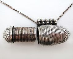 This is a rare 19th-century Indian antique silver and white metal amulet necklace. The amulet has a disguised cap on one end, which unscrews with an exaggerated screwing mechanism to reveal a container, this is used for keeping talismans or other protective objects. The amulet is made from silver and white metal. It has a suspension loop decorated with flower heads.  The vintage sterling silver box-chain necklace is a later addition, stamped with Italian silver hallmarks and 925.  Similar exampl Yemeni Jewelry, Yemenite Jews, Andromeda Constellation, Seashell Design, Talisman Pendant, Zoom Photo, Amulet Necklace, Ancient Jewelry, Amulets