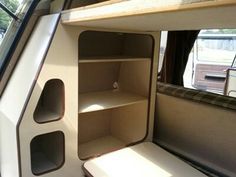 the inside of a camper with shelves and cupboards on each side of the door