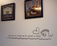 two coffee cups are on the wall next to some framed pictures with words above them