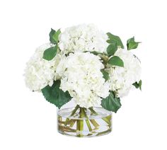 a clear vase filled with white flowers on top of a table next to a green leafy plant