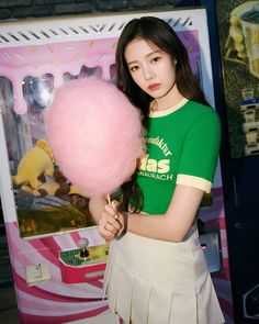 a young woman holding a pink cotton candy