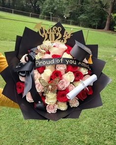 a bouquet of flowers is being held by someone in the grass with a graduation cap on it