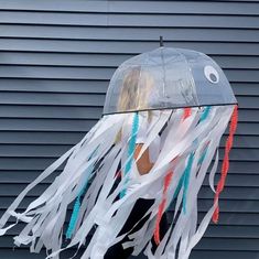 a woman wearing a plastic jellyfish hat with streamers