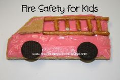 a pink fire truck shaped cake with pretzels on the front and side for kids to eat