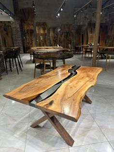 a wooden table sitting on top of a tiled floor next to tables with chairs in the background