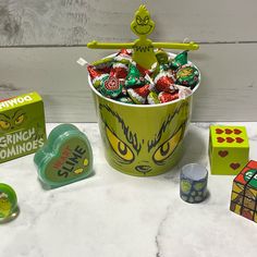 a bucket filled with candy sitting on top of a table next to other candies