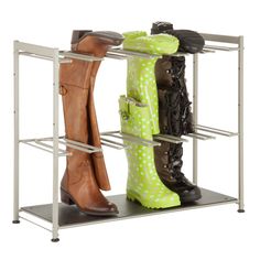 three pairs of boots are sitting on a shelf in front of the shoe rack that holds four pairs of shoes