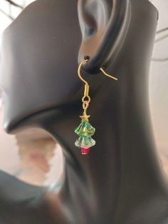 Crystal Lily Shaped bead Christmas Tree Earrings that come in two variations, silver and gold toned stars. ⚬ Free shipping on all orders $35 or above ⚬ Each piece is handmade ⚬ Made in the USA. ⚬ More in our shop: https://www.etsy.com/shop/BellaLilahJewelry QUESTIONS? Please feel free to message me anytime! I'd love to hear it and I'm ready to answer all of your questions! Thank you for visiting Bella Lilah. Handmade Jewelry For Christmas Celebration, Christmas Dangle Jewelry For Celebration, Festive Holiday Jewelry With Dangle Shape, Dangle Jewelry For Christmas Celebration, Festive Holiday Dangle Jewelry, Christmas Celebration Dangle Jewelry, Christmas Party Beaded Dangling Earrings, Holiday Jewelry With Dangling Beads, Christmas Party Dangling Beaded Earrings