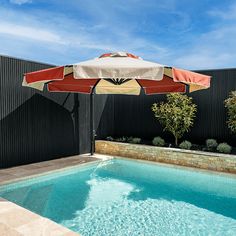 an umbrella over the edge of a swimming pool