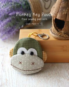 a monkey keychain sitting on top of a wooden block next to a birdhouse