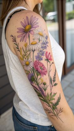 a woman's arm with flowers painted on the back of her body and shoulder