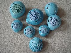 blue ceramic ornaments are on the floor next to each other, including one shell and five seashells