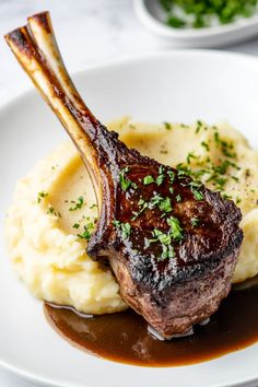 a piece of steak and mashed potatoes on a white plate