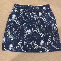 Navy Blue Mini Skirt With Floral Print. Built In Skirts Blue Floral Print Skort For Spring, Blue Pencil Skirt Skort For Spring, Blue Floral Print Relaxed Mini Skirt, Blue Floral Print Relaxed Fit Mini Skirt, Blue Relaxed Fit Mini Skirt With Floral Print, Blue Pencil Skort With Lined Skirt, Blue Pencil Skirt Skort For Summer, Blue Pencil Skirt Lined Skort, Blue Lined Pencil Skirt Skort