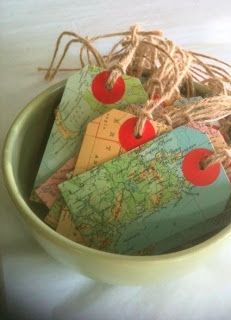 a green bowl filled with lots of different colored luggage tags on top of a white table