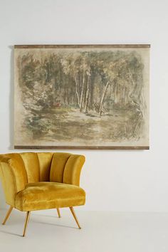 a yellow chair sitting in front of a painting